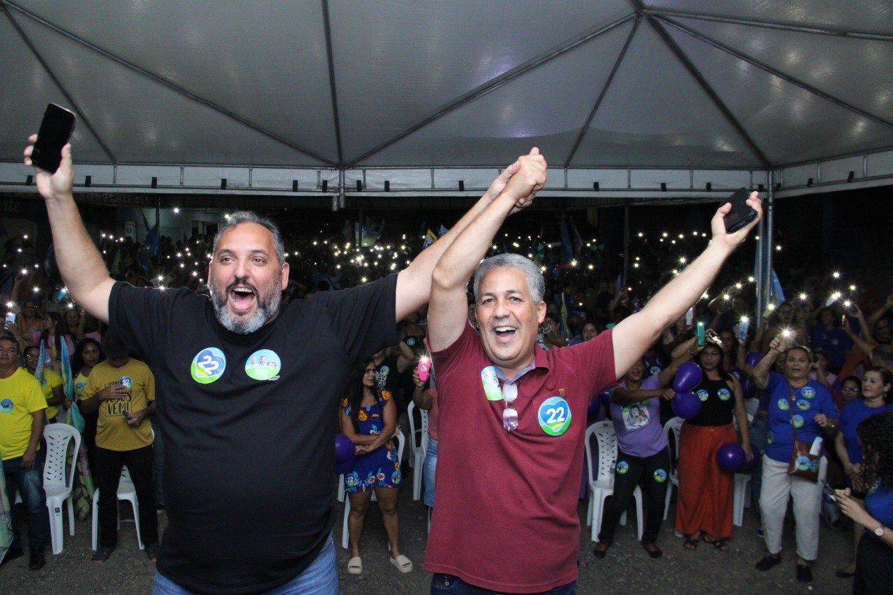 Rodrigo Medeiros e o pastor André Paixão comemorando o sucesso do evento e a multidão de apoiadores ao fundo com as luzes das lanternas de seus celulares acesas - Foto: ASCOM Rodrigo Medeiros 