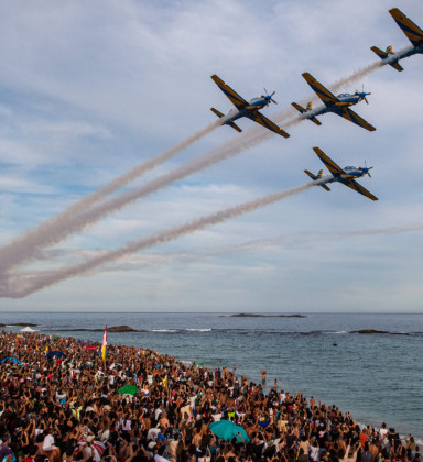 Aviões da Esquadrilha Céu realizam manobra sincronizada sobre as areias lotadas de Itaúna, proporcionando um espetáculo de tirar o fôlego para o público em Saquarema. - Foto: Reprodução. 